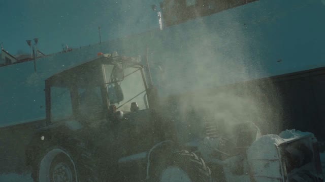 Tractor Cleans Snow. Snow Flies In The Camera