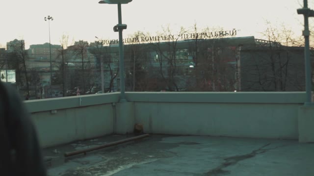 Young Man Stands On The Roof On A Skateboard