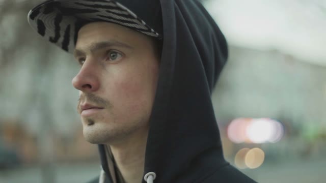 Man In A Cap Pulls Earphone Close-up