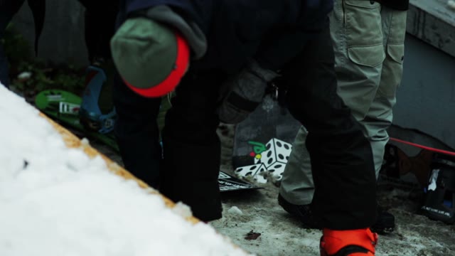 Man Fastening Buttons On A Snowboard