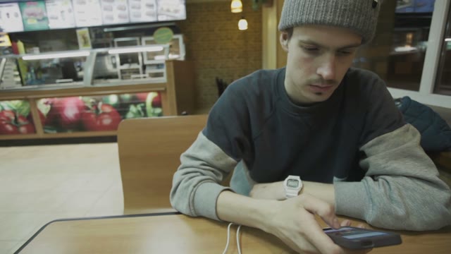 Man Showing A Photo On The Smartphone In A Cafe