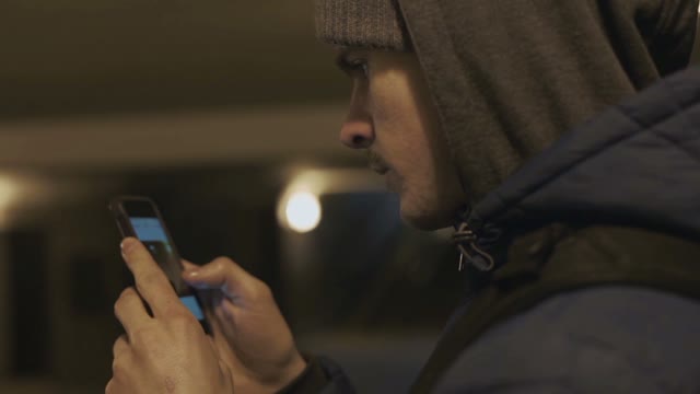 Man Uses A Smartphone In The Underpass Close-up