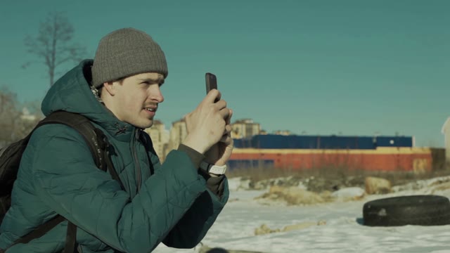 Man Sitting With A Smartphone In The Hands Outdoors