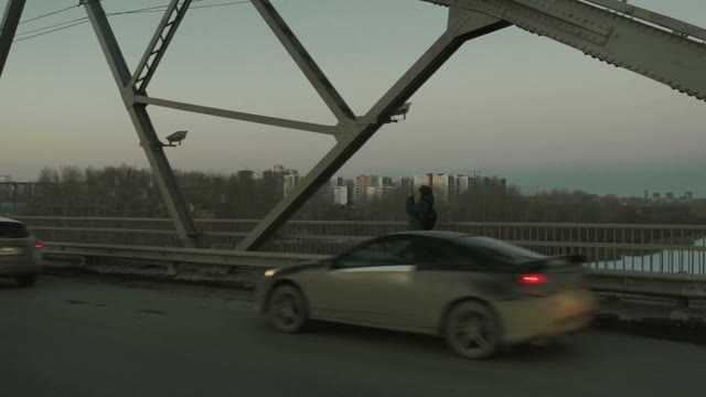Man Standing On The Bridge And Takes Pictures