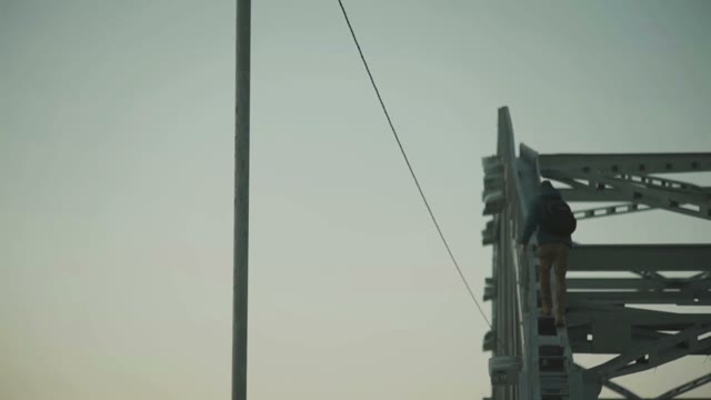 Man Climbs On Metal Structure