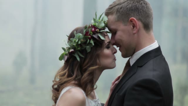 Newlyweds Standing In A Forest In The Midst Of Smoke Close-up