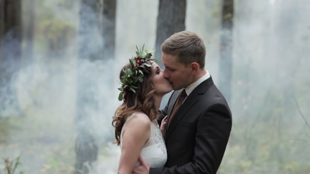 Newlyweds Kissing In A Forest In The Midst Of Smoke