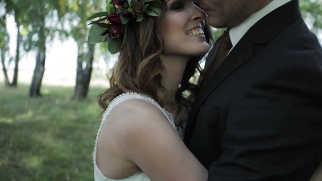Newlywed Couple Hugging And Kissing In The Forest