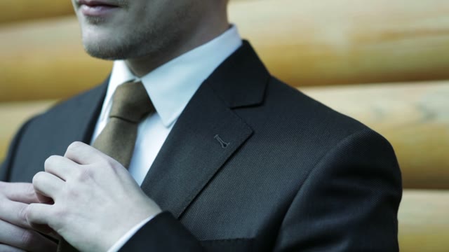 Man Adjusts Necktie Close-up