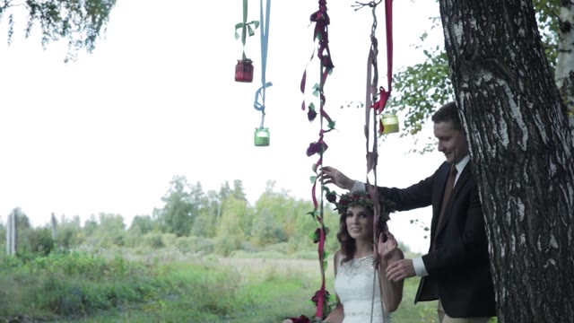 Groom Rocking Bride On A Swing