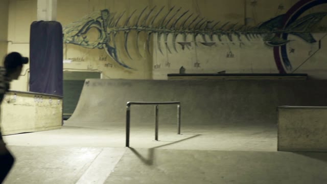 Young Man Does A Trick On A Skateboard On The Rails
