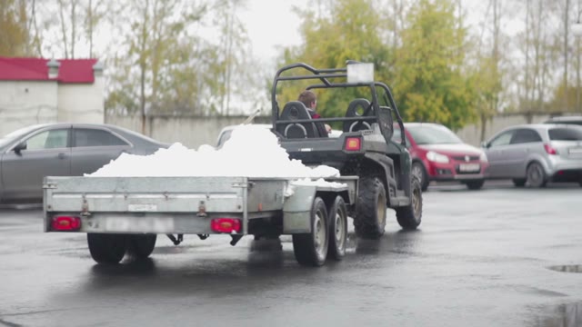 Worker Transporting Snow In The Trailer