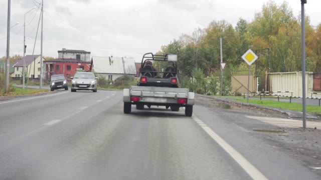 Car With A Trailer Traveling On The Road