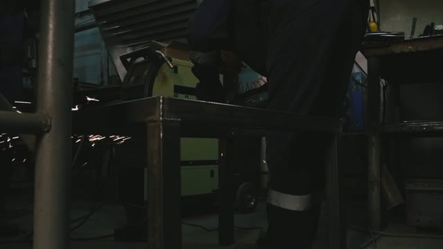 A Man Working With A Power Saw Indoor