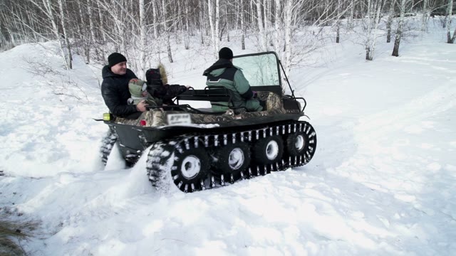 Man Rolls The Family For A Snowmobile In The Woods