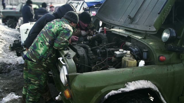 Three Men Trying To Repair The Car In A Forest