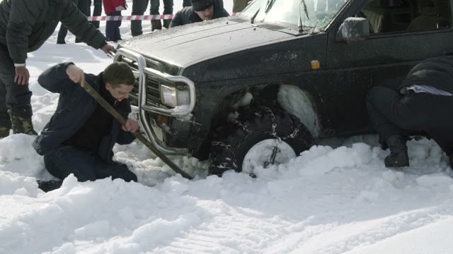 Several Men Dig The Car Stuck In The Snow