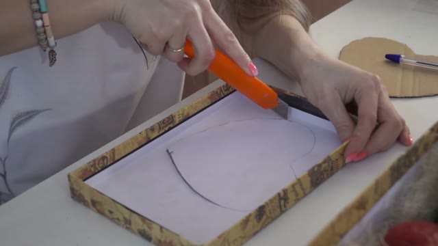 Girl Cuts The Heart Out Of Cardboard Stencil