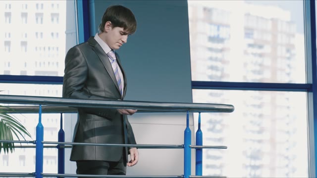 Businessman Answers The Phone In A Shopping Center