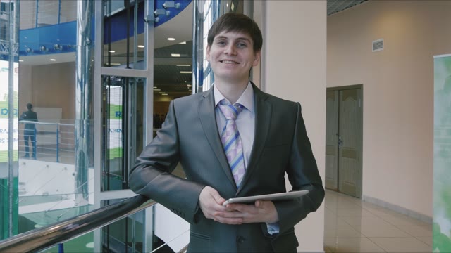 Young Businessman Smiling With A Tablet In Hands