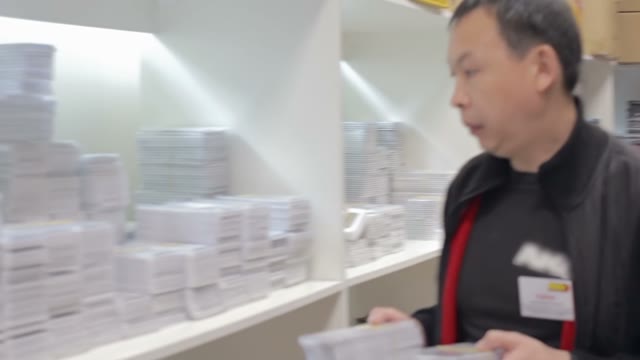 Shopkeeper Holds An Inventory Of Equipment In The Shop
