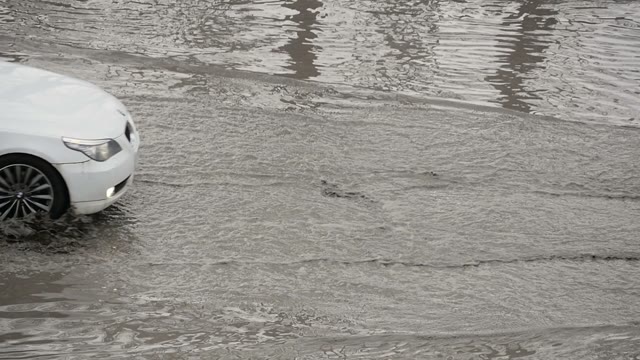 Car Drives Through A Large Puddle Of Dirt