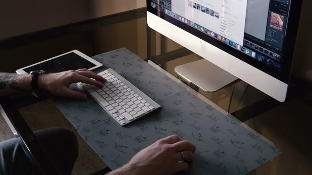 Young Man Works On The Computer And A Tablet
