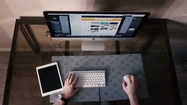 Young Man Works On The Computer And A Tablet