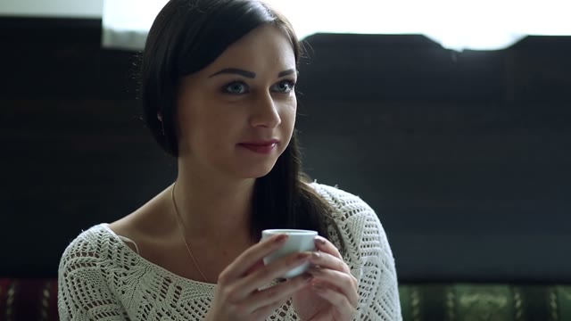 Girl In The Coffee Bar At The Table Enjoying A Cup Of Fine Drink
