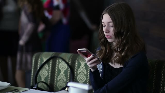 Girl With A Phone In The Cafe