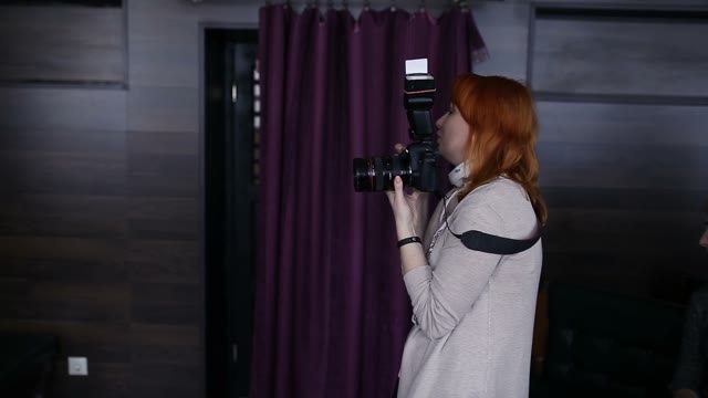 Woman Photographer With Red Hair Makes A Photo On The Camera