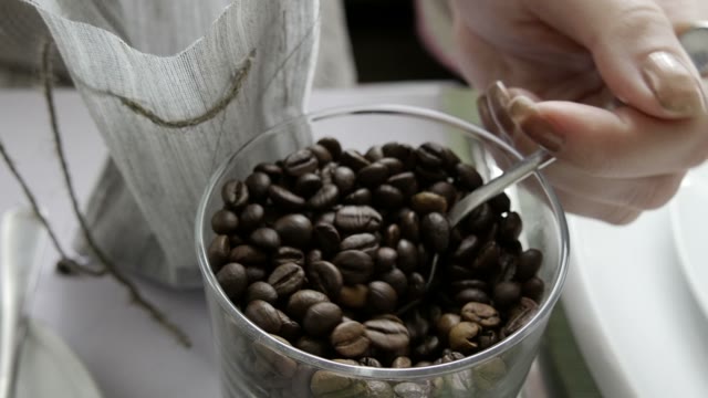 The Girl In The Cafe Makes A Bag With A Coffee Beans