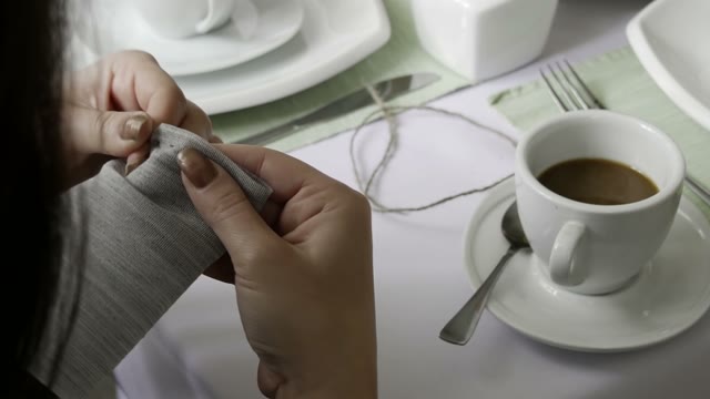 The Girl In The Cafe Makes A Bag With A Coffee Beans