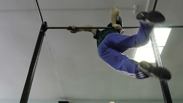 Man Doing Exercises On The Horizontal Bar In The Gym
