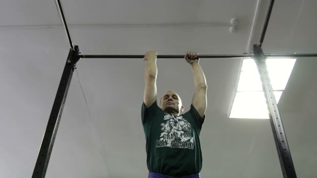 Man Doing Exercises On The Horizontal Bar In The Gym