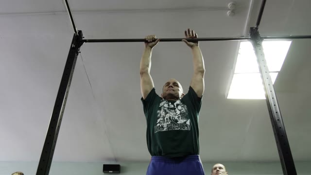 Man Doing Exercises On The Horizontal Bar In The Gym