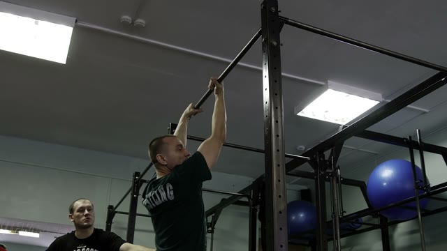 Man Doing Exercises On The Horizontal Bar In The Gym