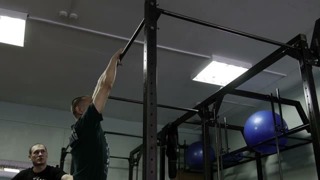 Man Doing Exercises On The Horizontal Bar In The Gym
