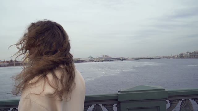 Cute Young Curly Girl Goes Over The Bridge Across The River