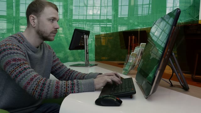Young Man Working At The Computer In The Office