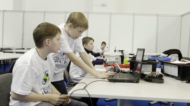 Children Work On A Computer To Create A Robot