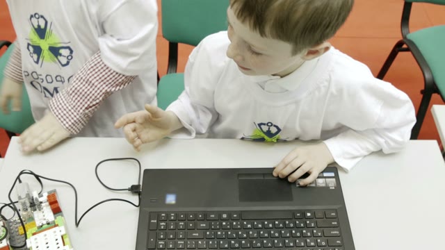 Children Work On A Computer To Create A Robot