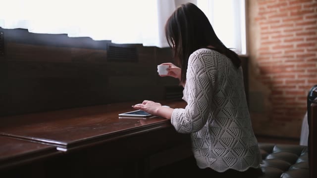Pretty Girl Drinking Coffee And Working On The Tablet