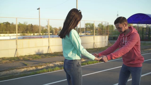 The Guy Holding The Girl By The Hand And Go On A Hoverboard
