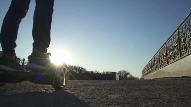 Man And Woman Hold Hands And Ride On Hoverboard