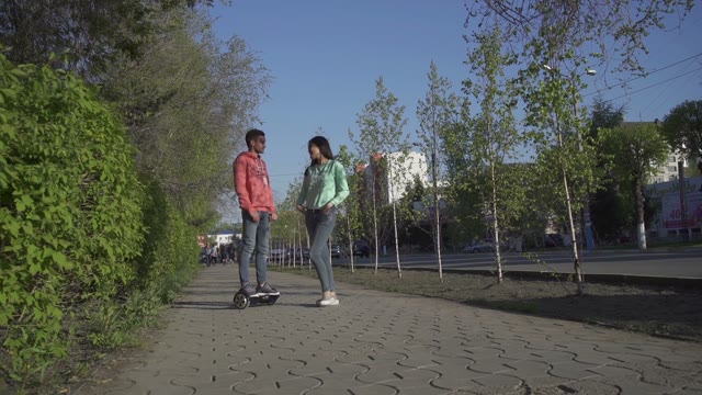 Young Man Rides On Hoverboard For Asian Girl