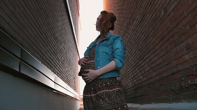Pretty Pregnant Woman Stroking Her Belly