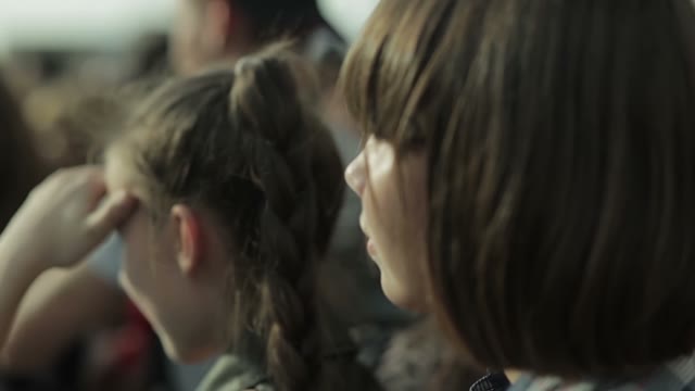 Young Girl Watching The Competitions On A Snowboard