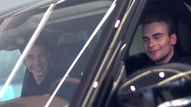 Two Young Men Laughing In Car Salon