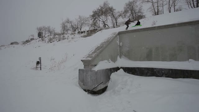 Snowboarder Doing A Trick On A Ledge In The Street